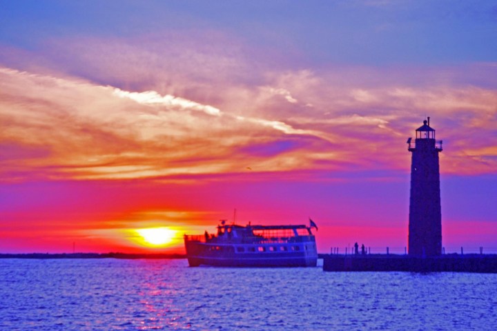 a sunset over a body of water with a city in the background