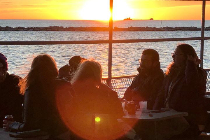a group of people sitting in front of a body of water