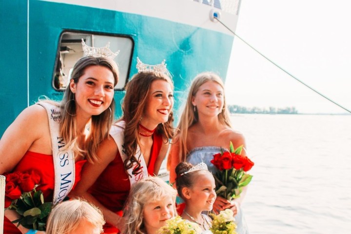 a group of people standing in a body of water posing for the camera