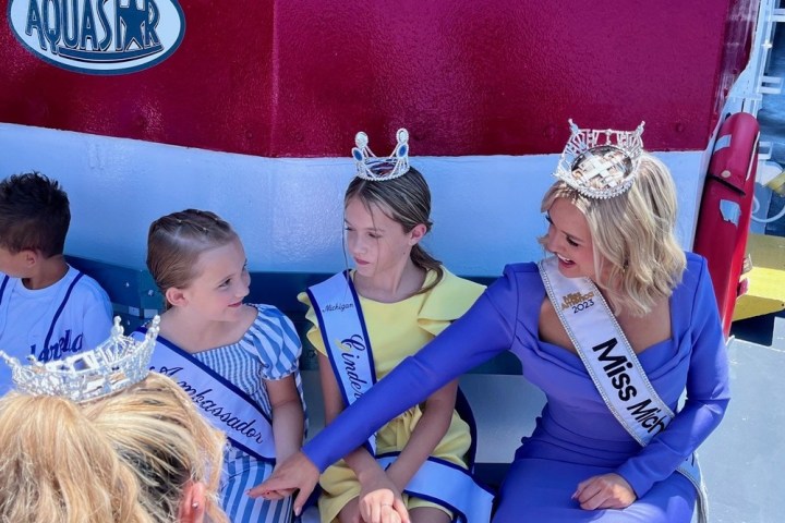 a group of people wearing blue shirts sitting next to a woman